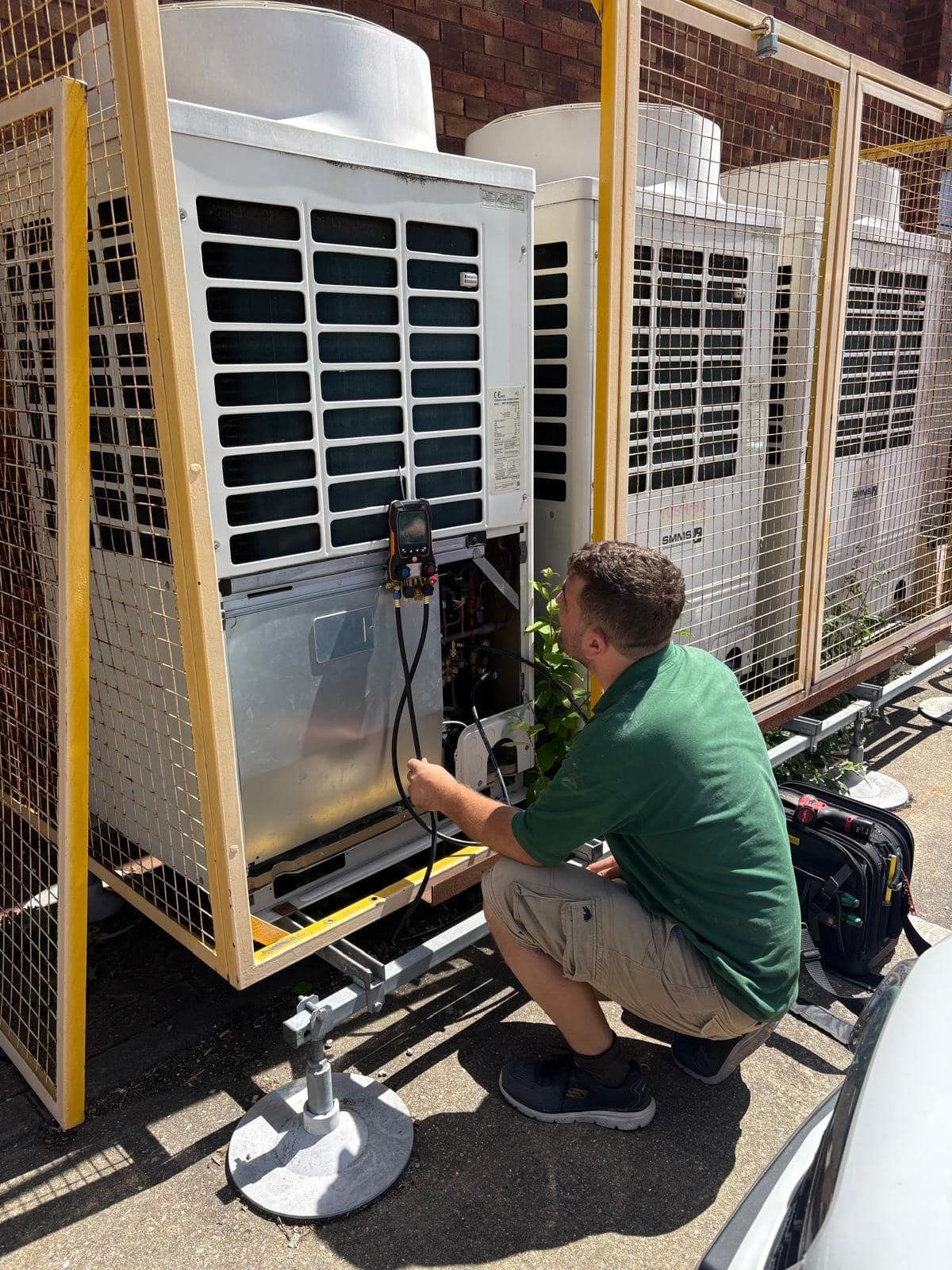 AM Heating engineer running system diagnostics on a VRF air conditioning outdoor unit in London